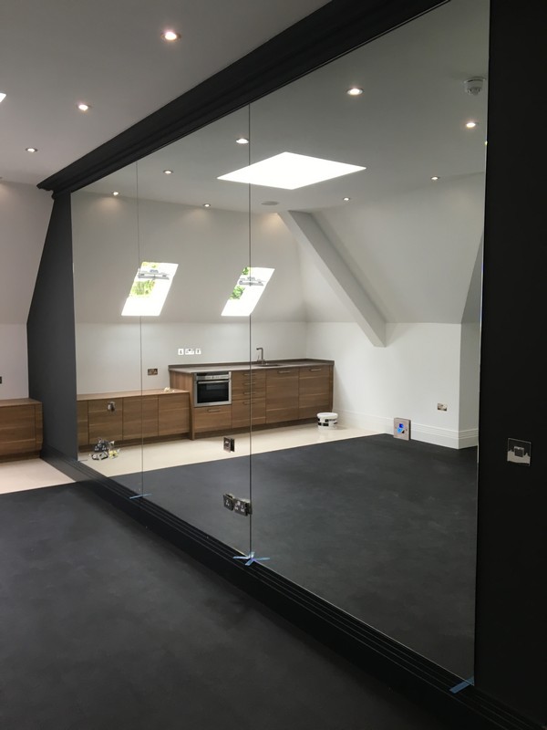 Frameless glass partition in loft conversion by Tooting glaziers