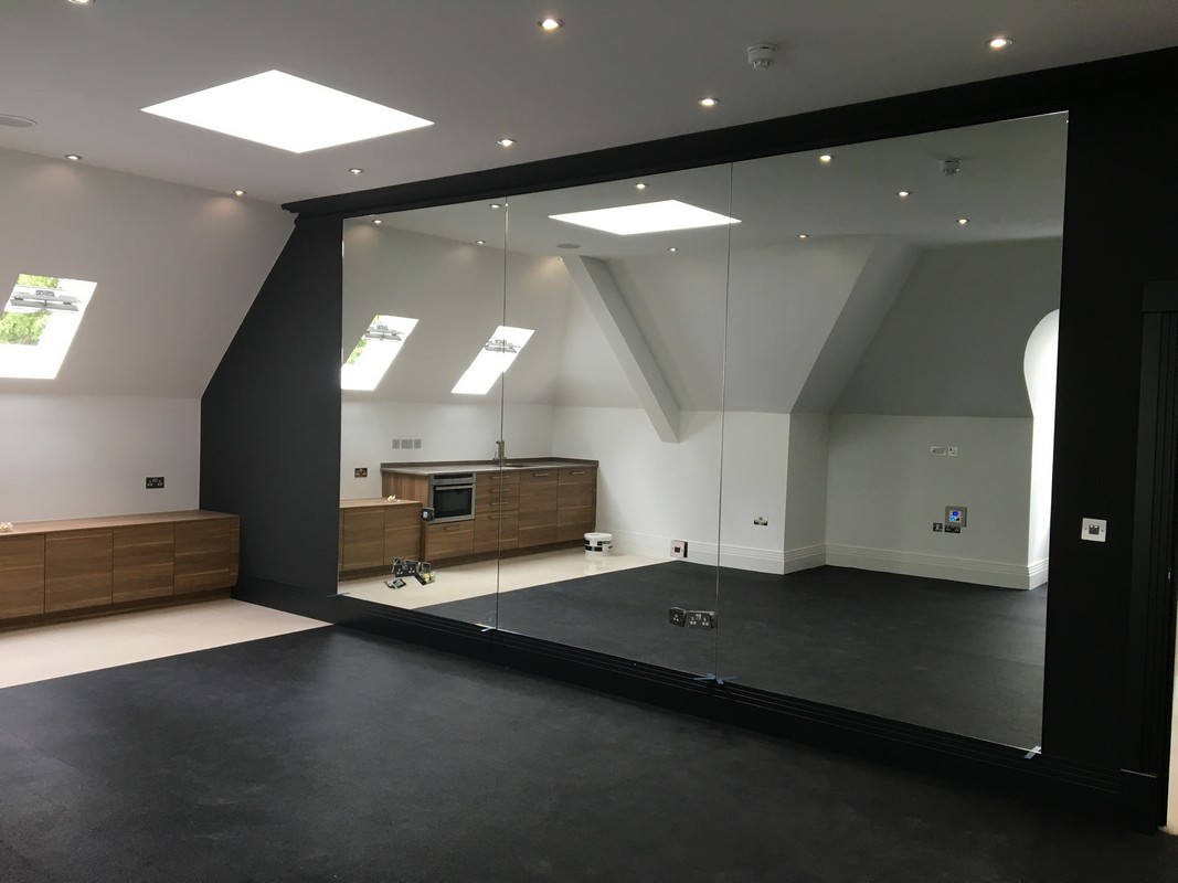 Frameless glass wall dividing loft conversion in Tooting
